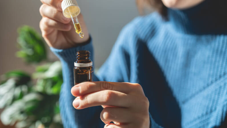 Woman holding bottle of cannabis oil for anxiety treatment