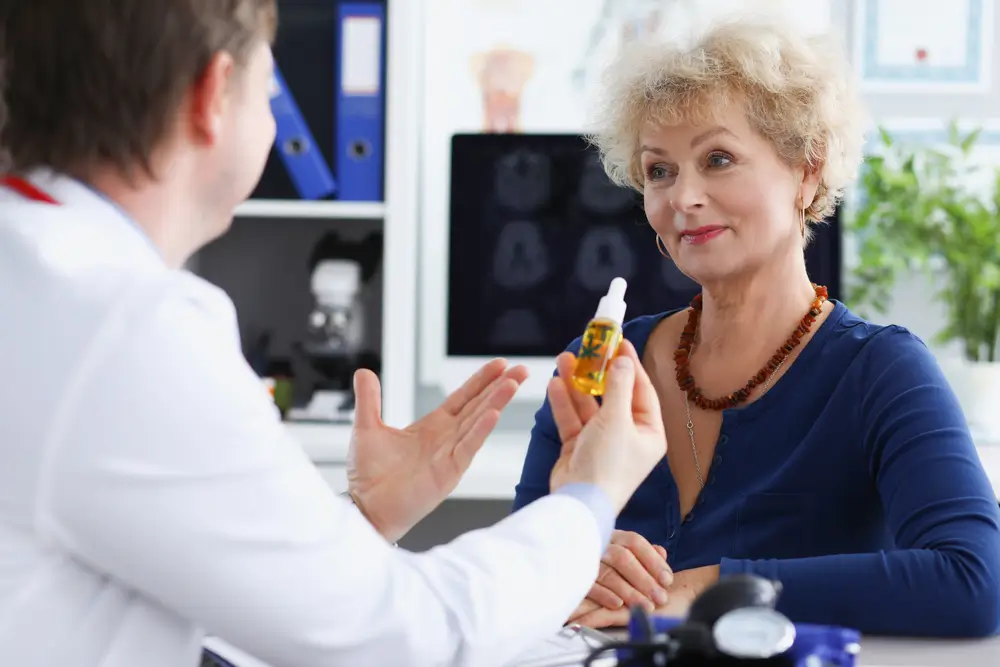 Doctor passes cbd oil to elderly woman 