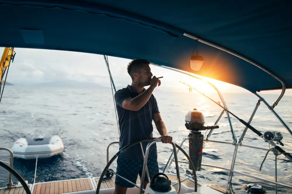 Man enjoying cigar at sailboat helm