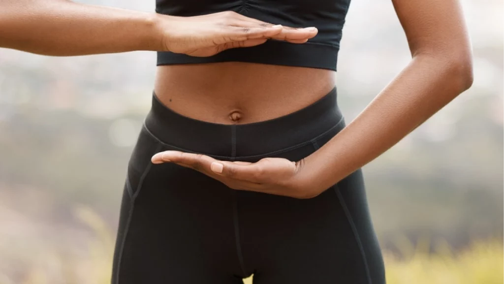 Woman, nature and hands for gut health with balance, outdoor exercise for spiritual wellness. Female person, fitness and digestion in countryside with healing, training or stomach workout for colon