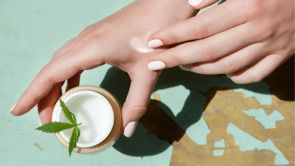 Cannabis cream with marijuana leaf in hands. Concept of herbal alternative medicine, cbd oil, pharmaceptical industry, cannabis cosmetics