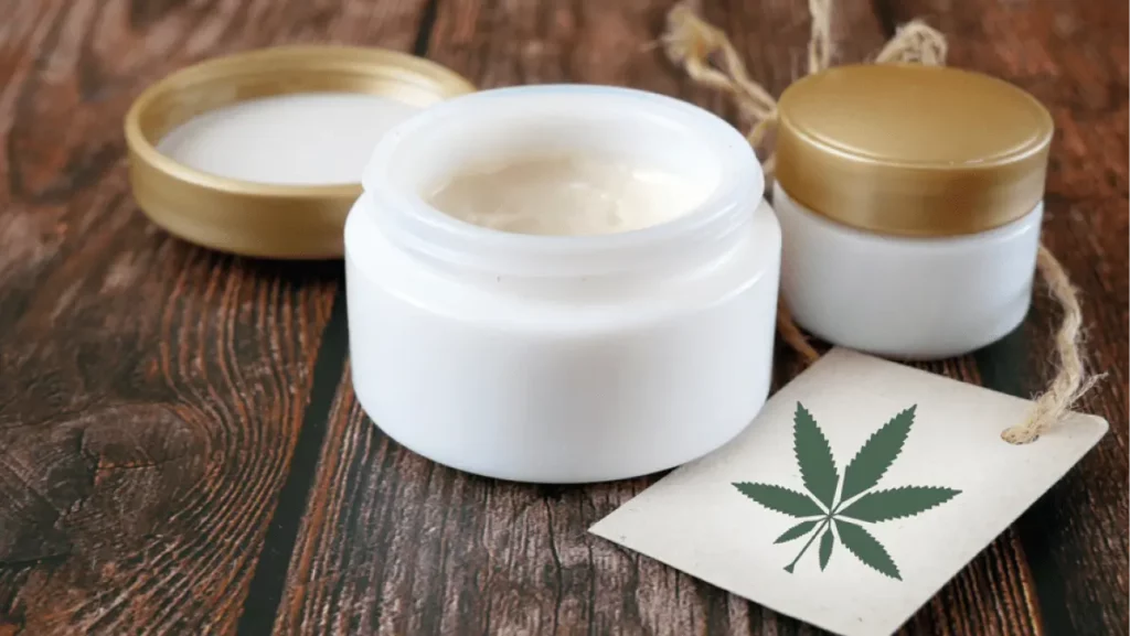 Jar of hemp white lotion. Detail of cannabis cream with marijuana leaf - cannabis topicals concept. Cream from biological and ecological plants of hemp vegetable pharmaceutical oil CBD